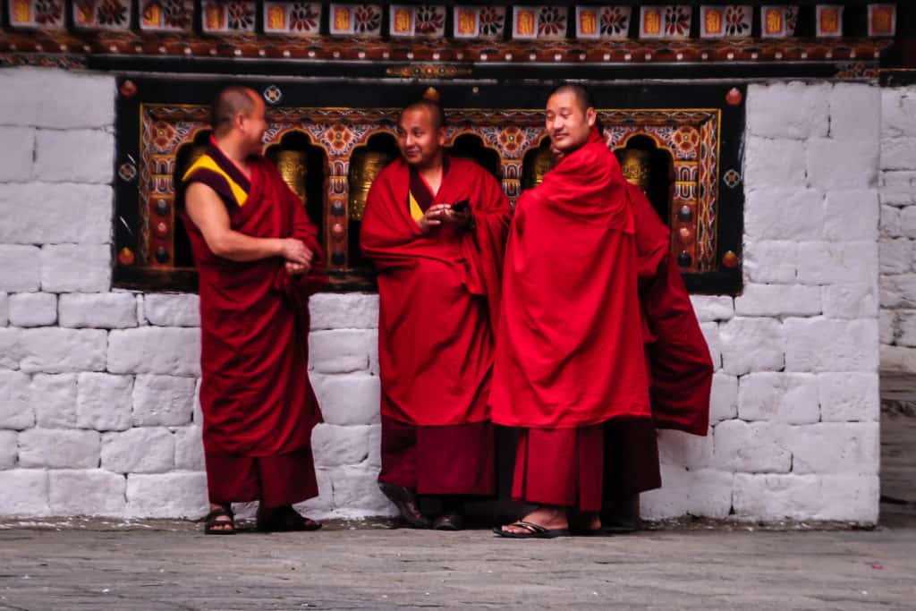 Thimphu Tashichho Dzong monks in front of prayer mills