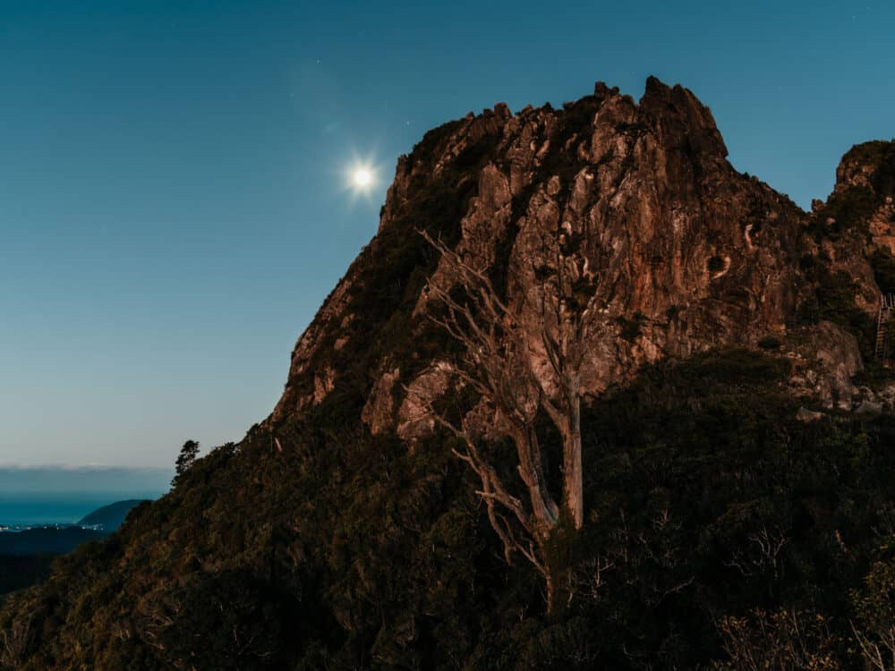Full rises behind Coromandel Pinnacles during blue hour after sunset
